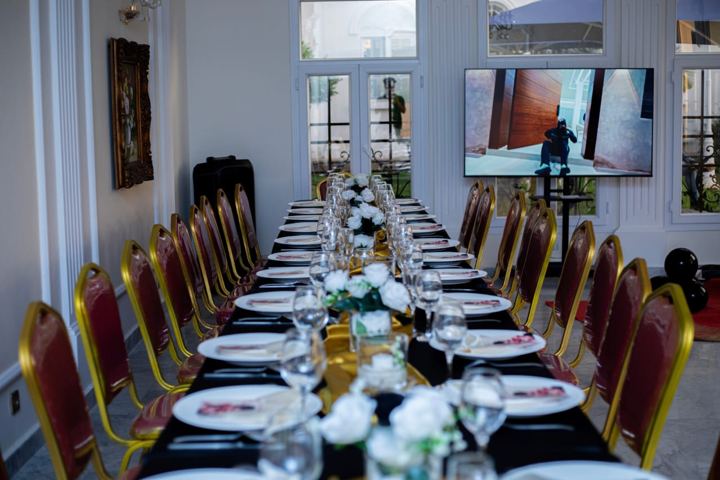 Salle dressée pour un dîner d'entreprise avec écran